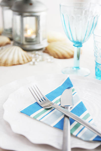 istock Place setting with blue striped napkin on scalloped dishes 184383284