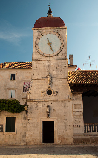 Ancient stone wall of old building with sundial at Krk, Croatia