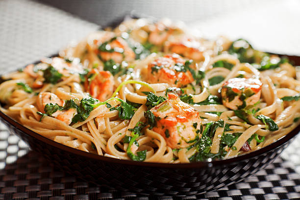 Penne with grilled salmon and white wine on a table