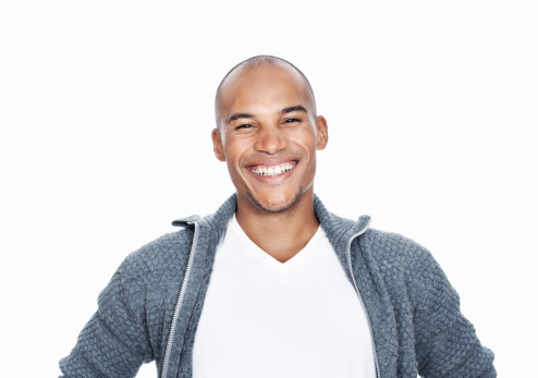 Portrait of handsome African American male executive smiling on white background