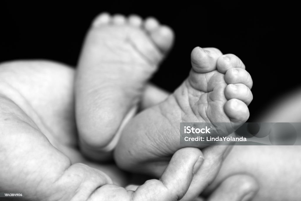 新生児の足を母の手 - アウトフォーカスのロイヤリティフリーストックフォト