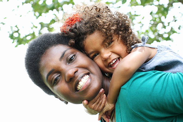 istock Happy little black kid with smiling mother, on her back 184385380