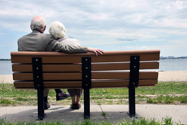 istock Senior Couple Sitting On The Park Bench 184385545