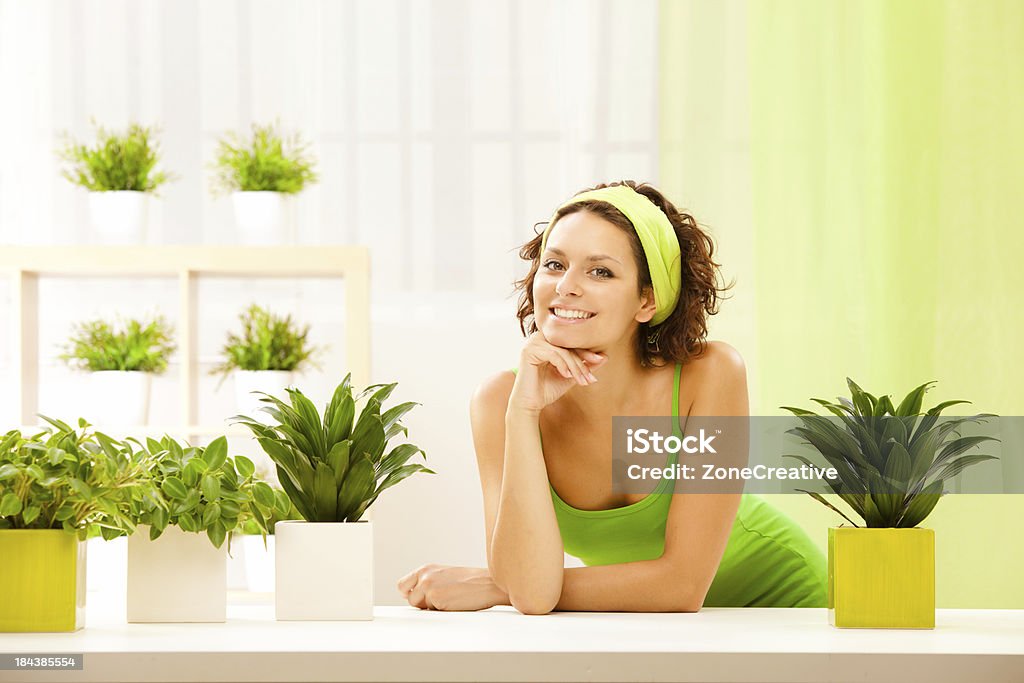 Bellissima giovane donna con sorriso verde piante rilassato - Foto stock royalty-free di Capelli corti