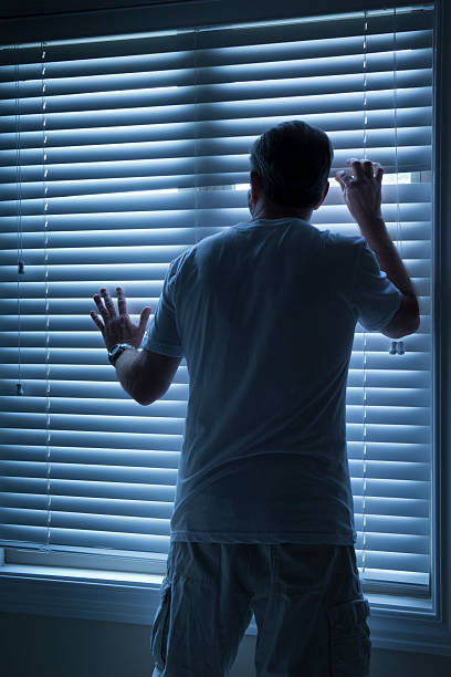 istock Homeowner Nervously Checks On Outside Noise Late At Night 184385849