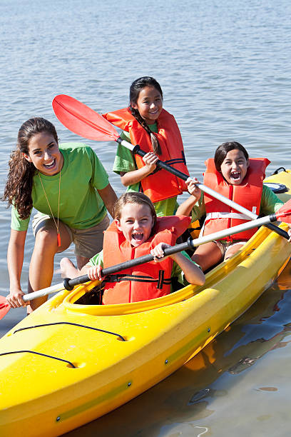 duas garotas em um caiaque, - summer camp child teenager kayak - fotografias e filmes do acervo