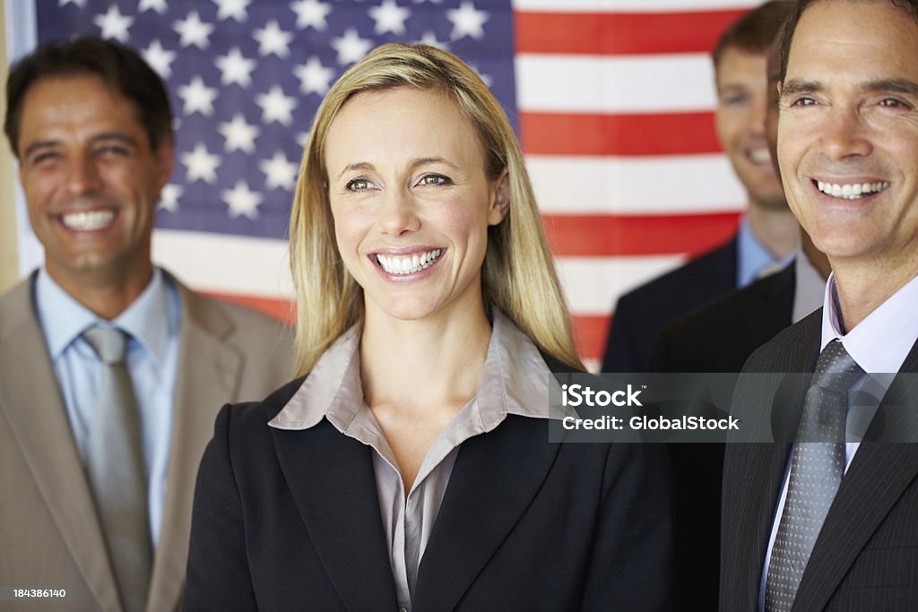 Confident executives smiling in front of flag Portrait of confident business associates smiling with flag in the background Senator Stock Photo