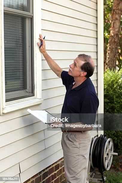 Home Inspector Examining The Window Outside Of A White House Stock Photo - Download Image Now