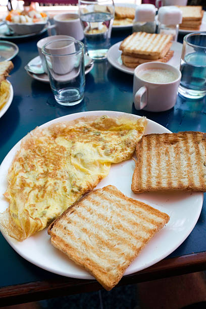 Omelet with spinach, mushrooms and chorizo cooked in old vintage pan served with three slices of bread