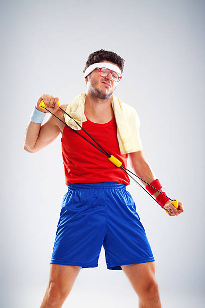 Nerdy sportsman having problem with resistance band