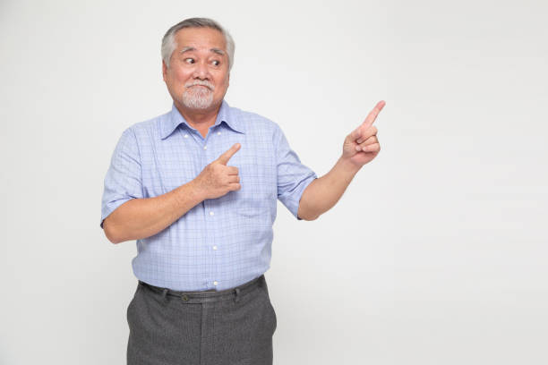 istock Happy Asian old man pointing to copy space blank space isolated on white background 1843906317
