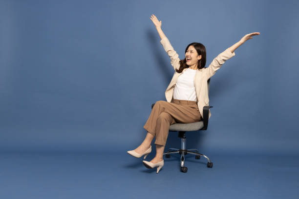 매력적인 아름 다운 아시아 여성이 사무실 의자에 앉아서 행복에서 팔을 들어 올린 손을 들고, 흥분 된 사업가 우승자 성공 개념 - office chair cheering ecstatic success 뉴스 사진 이미지