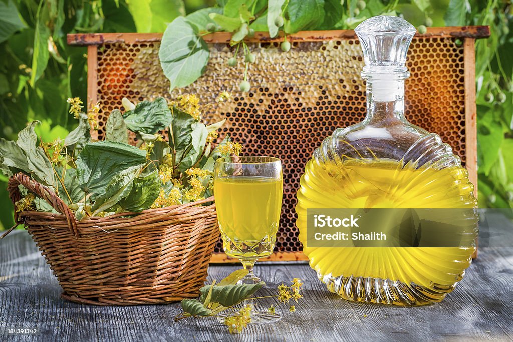 Homemade liqueur made of honey and lime in summer garden Homemade liqueur made of honey and lime in summer garden. Alcohol - Drink Stock Photo