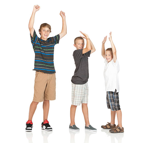 istock Portrait of three boys standing with their arms raised 184391463