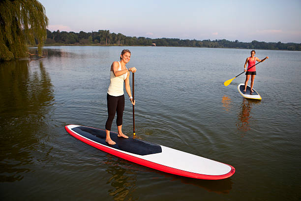 istock Two females paddle boarding on a lake 184392861