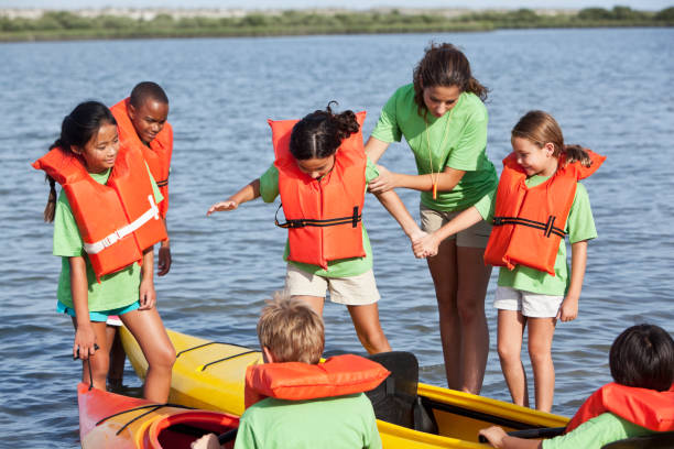 istock Summer camp counselor with children and kayaks 184393187