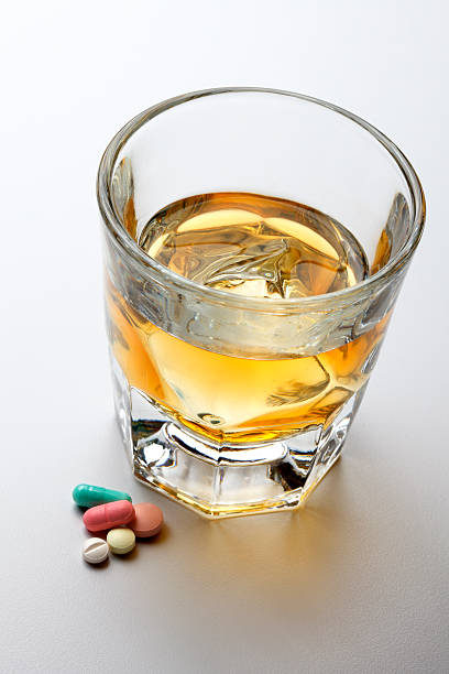 álcool e medicamentos de prescrição sobre fundo cinzento claro - alcohol drug abuse alcoholism pill imagens e fotografias de stock