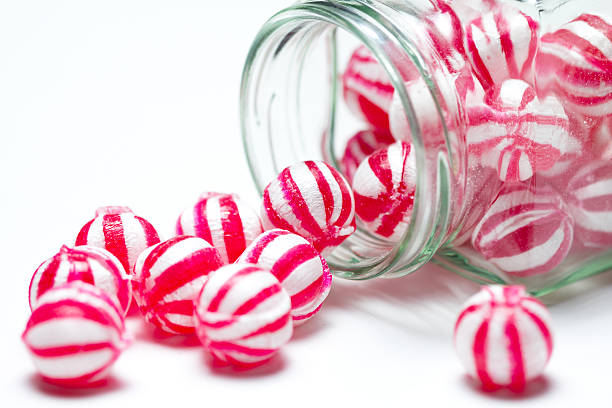 Close-up photo of red and white striped candies in a jar stock photo