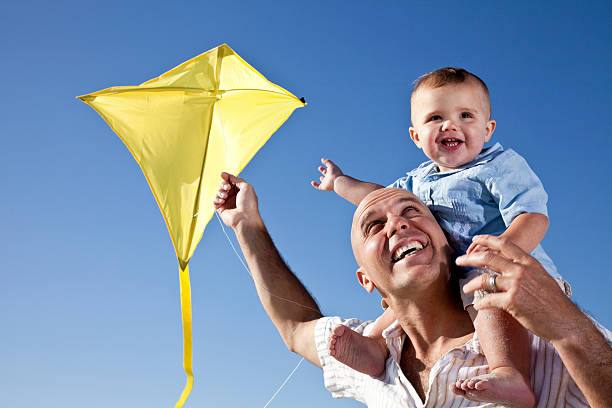 istock Father with little boy on shoulders flying kite 184393629