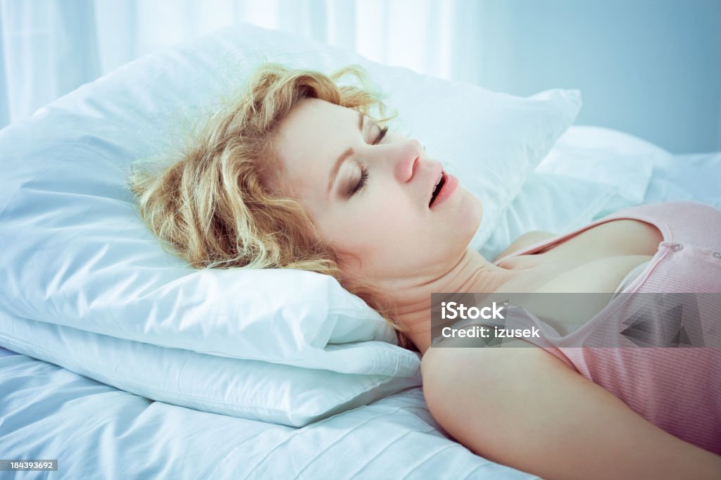 Snoring woman Beautifull young adult woman sleeping in a bad with mouth open and snoring, Snoring Stock Photo