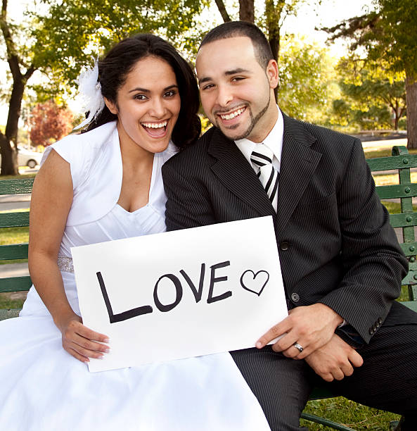 Bride and Groom outside with sign reading LOVE  
