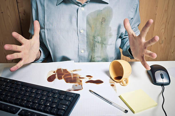 Spilled Coffee And Office Worker Sitting On The Desk