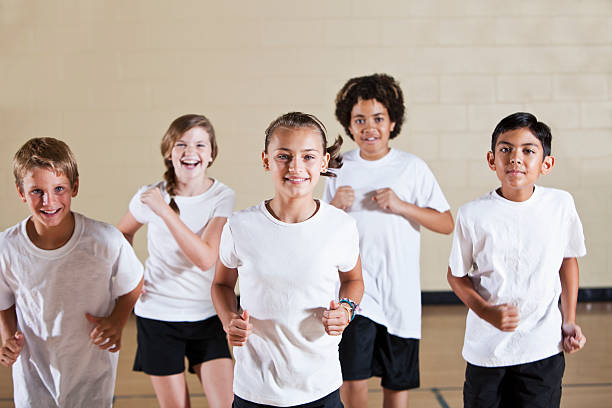 istock Group of children in phys ed class exercising 184394722