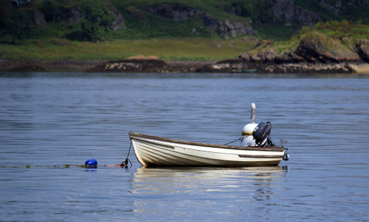 A small rowing boat with outboard motor. The picture was taken on the east coast of Scotland near Oban.