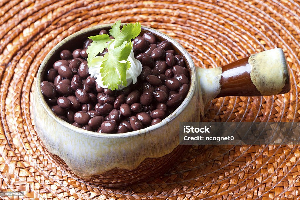 Beans with garnish Bowl of black beans with cilantro and sour cream Bean Stock Photo
