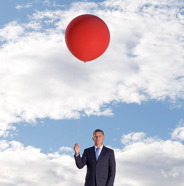 istock Mature businessman holding a balloon 184394843