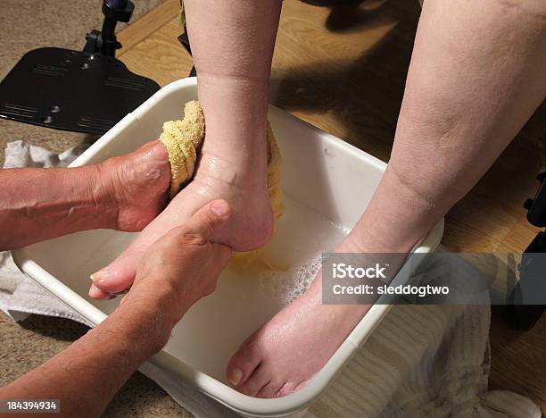 Person Washing Feet Of Another Person In Wheel Chair Stock Photo - Download Image Now