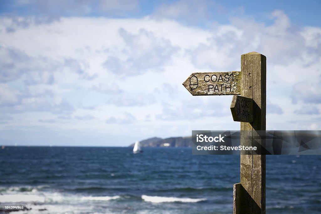 Coastpath poste indicador Inglaterra en la costa sur de mar azul - Foto de stock de Camino libre de derechos