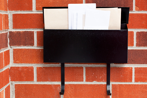 Mail fills a black metal home mailbox.