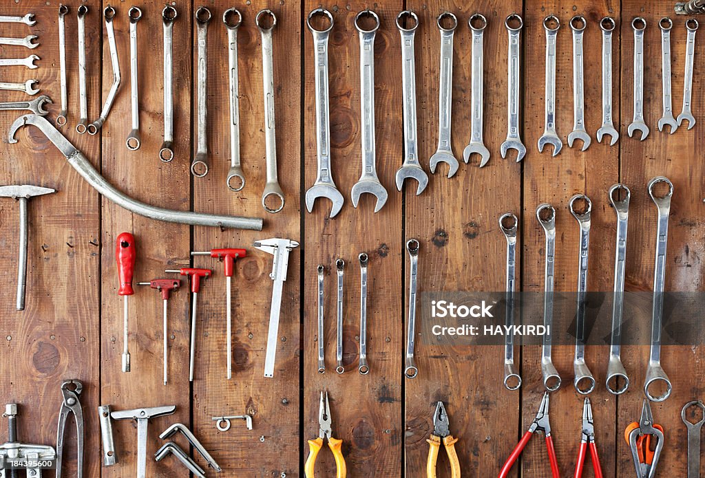 Hanging Tools Hanging Tools hang on a wood board in a garage. All identifiable brand names have been removed. Pegboard Stock Photo