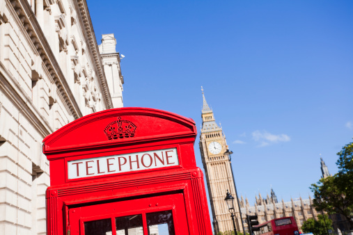 London Big Ben tower and red telephone box with a red Bus in Westminster London in a summer blue sky sunny day