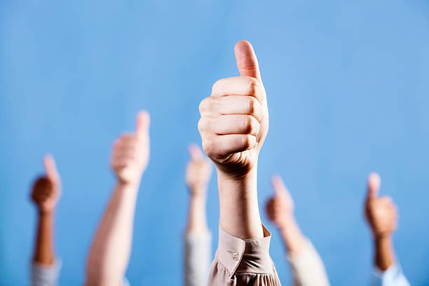 istock With focus on foreground, mixed group gives thumbs up sign 184395756