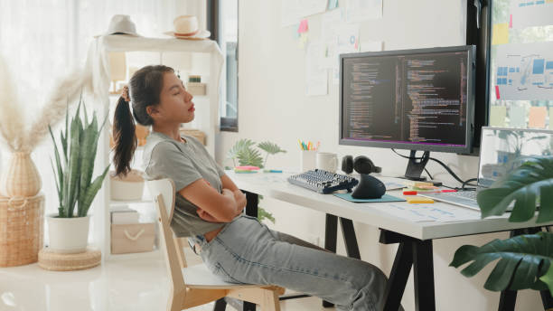istock Young girl development programmer overwork relax stretch muscle painful from office syndrome solve problem coding program fix database on computer on table in workplace at house office. 1843960882