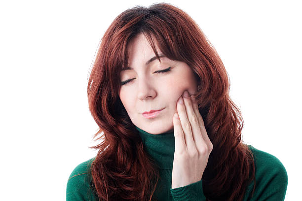 Toothache Woman rubbing her jaw in pain because of toothache clenching teeth stock pictures, royalty-free photos & images