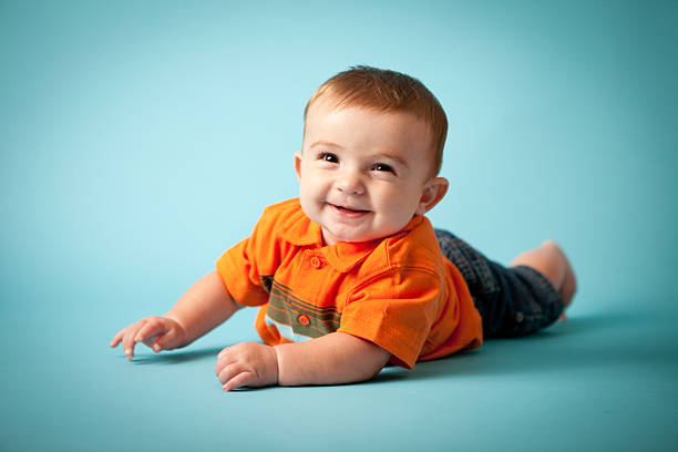 istock Happy Baby Boy Lying on His Front With Blue Background 184396944