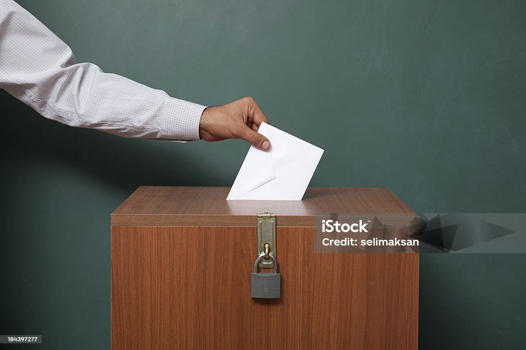 Hombre que agarra Encuesta sobre el cierre de la urna de voto - Foto de stock de Urna de voto libre de derechos