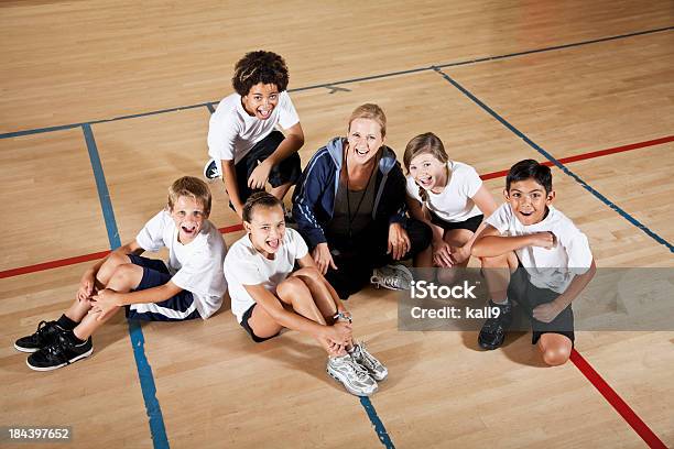 Coach With Group Of Children In Phys Ed Class Stock Photo - Download Image Now - 10-11 Years, 12-13 Years, 40-49 Years