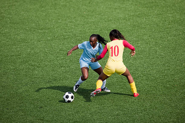 Womens Soccer Two women soccer players compete for the ball womens soccer stock pictures, royalty-free photos & images