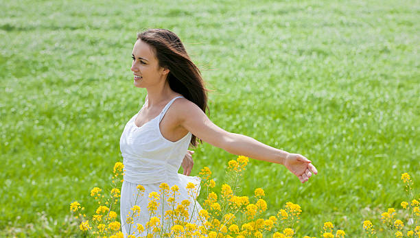 istock young woman enjoying the spring in meadow 184398373