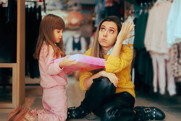 une fille demande à une mère exaspérée d’acheter ses jouets - pleading women business sadness photos et images de collection