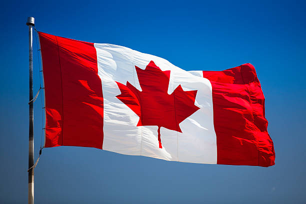 Canada symbol on a flagpole Maple leaf flag flying in the wind canadian flag stock pictures, royalty-free photos & images
