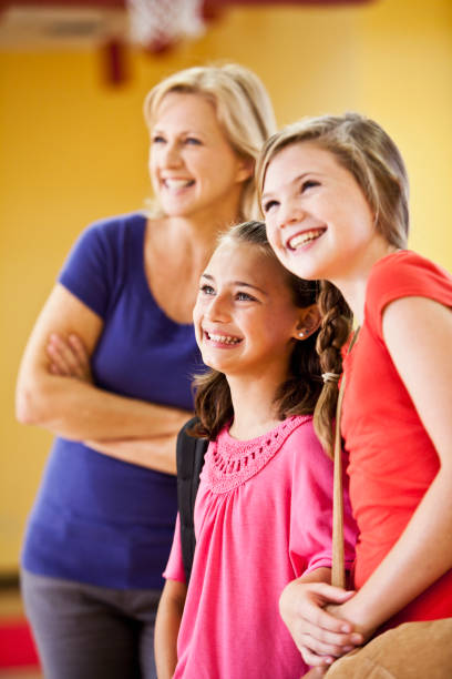istock Two girls with mother in background 184399613