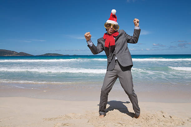 istock Holiday Santa Hat Businessman Dancing on Tropical Beach 184400222