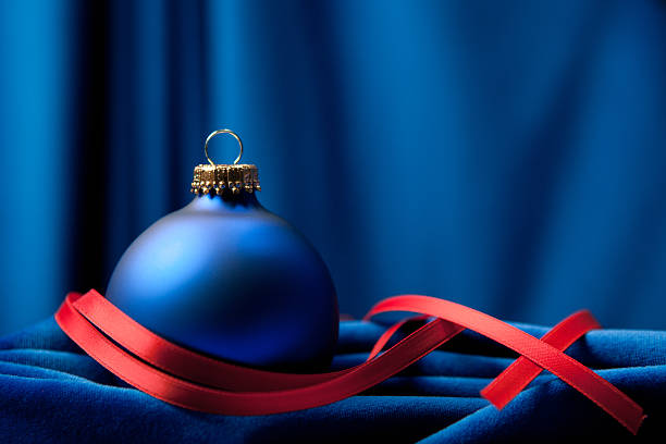 Christmas background composition with Christmas bauble on blue velvet.Soft focus and little grain added.