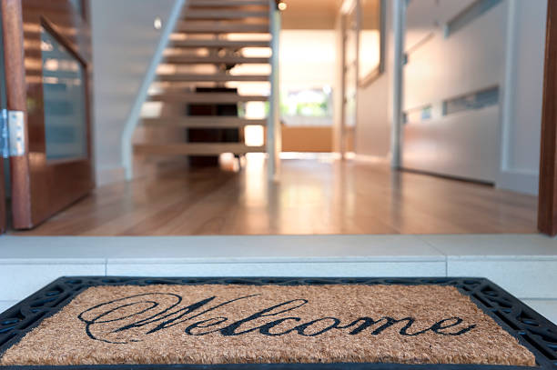 Close up of a welcome mat in an inviting house Close up of a welcome mat in front of an inviting house. Focus on foreground temptation stock pictures, royalty-free photos & images