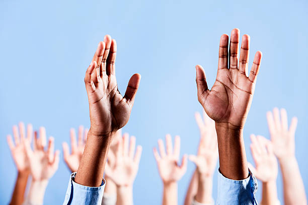 istock Man's raised hands with many more in background 184401180
